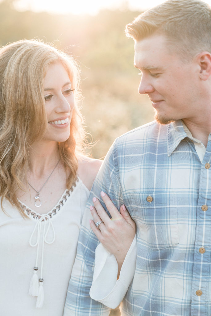 charlotte engagement photography shot of couple holding arms during sunset