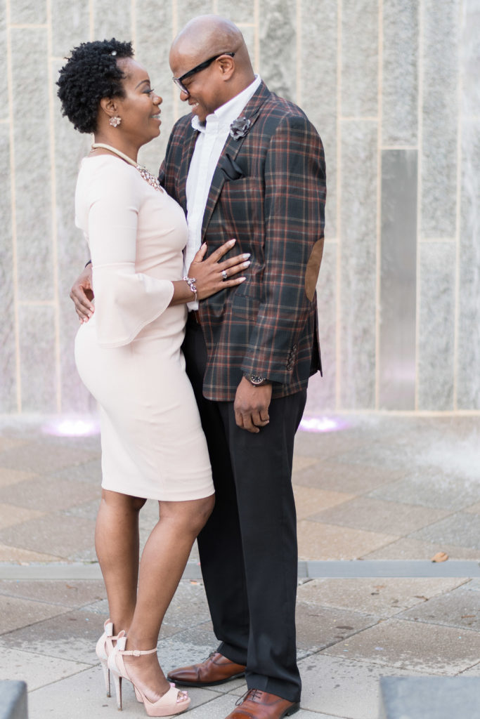 engagement photographer in charlotte capturing couple in romare bearden park in front of uptown fountain