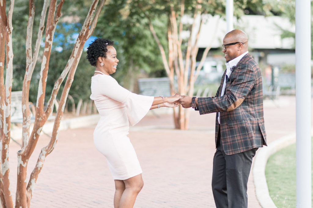 engagement photographer in charlotte capturing couple in romare bearden park dancing together