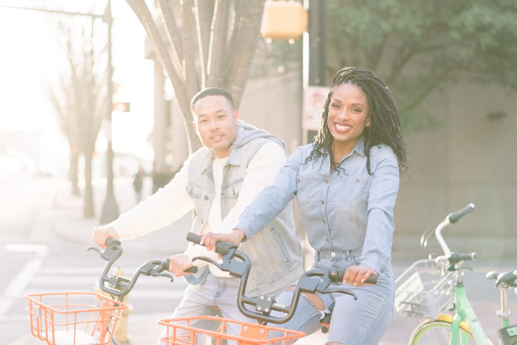charlotte Engagement Photography Romare Bearden Park shot of couple on mo bike and lime bike during engagement session and golden hour