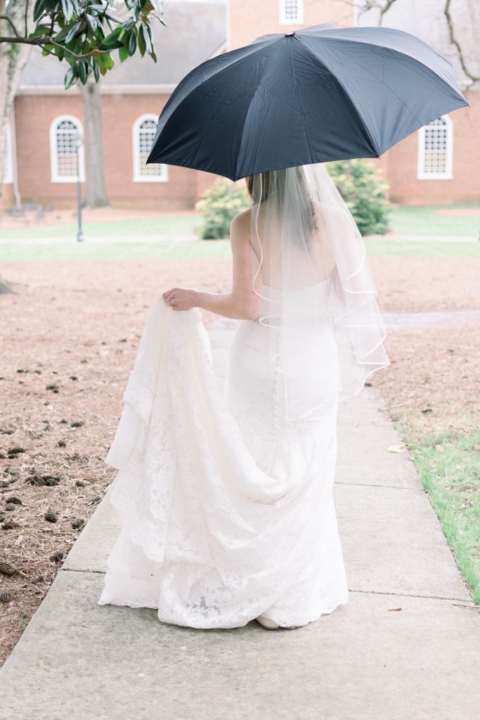 Wedding Photographer in Charlotte NC South Park Forrest Hill Church bride in white dress walks with a black umbrella