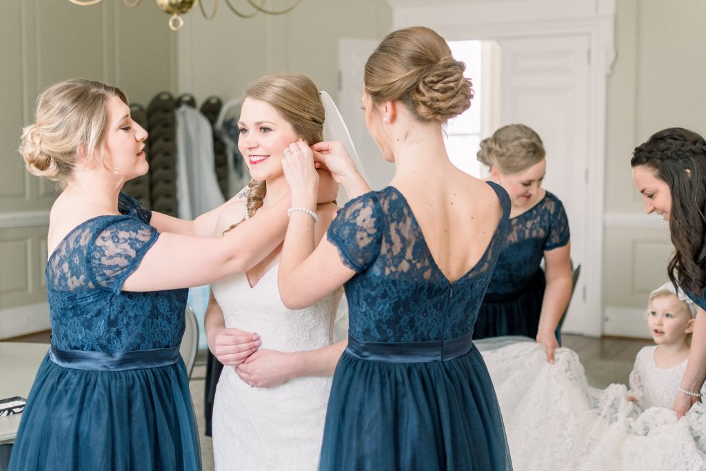 Wedding Photographer in Charlotte NC South Park Forrest Hill Church bridesmaids get bride ready before the ceremony with blue dresses