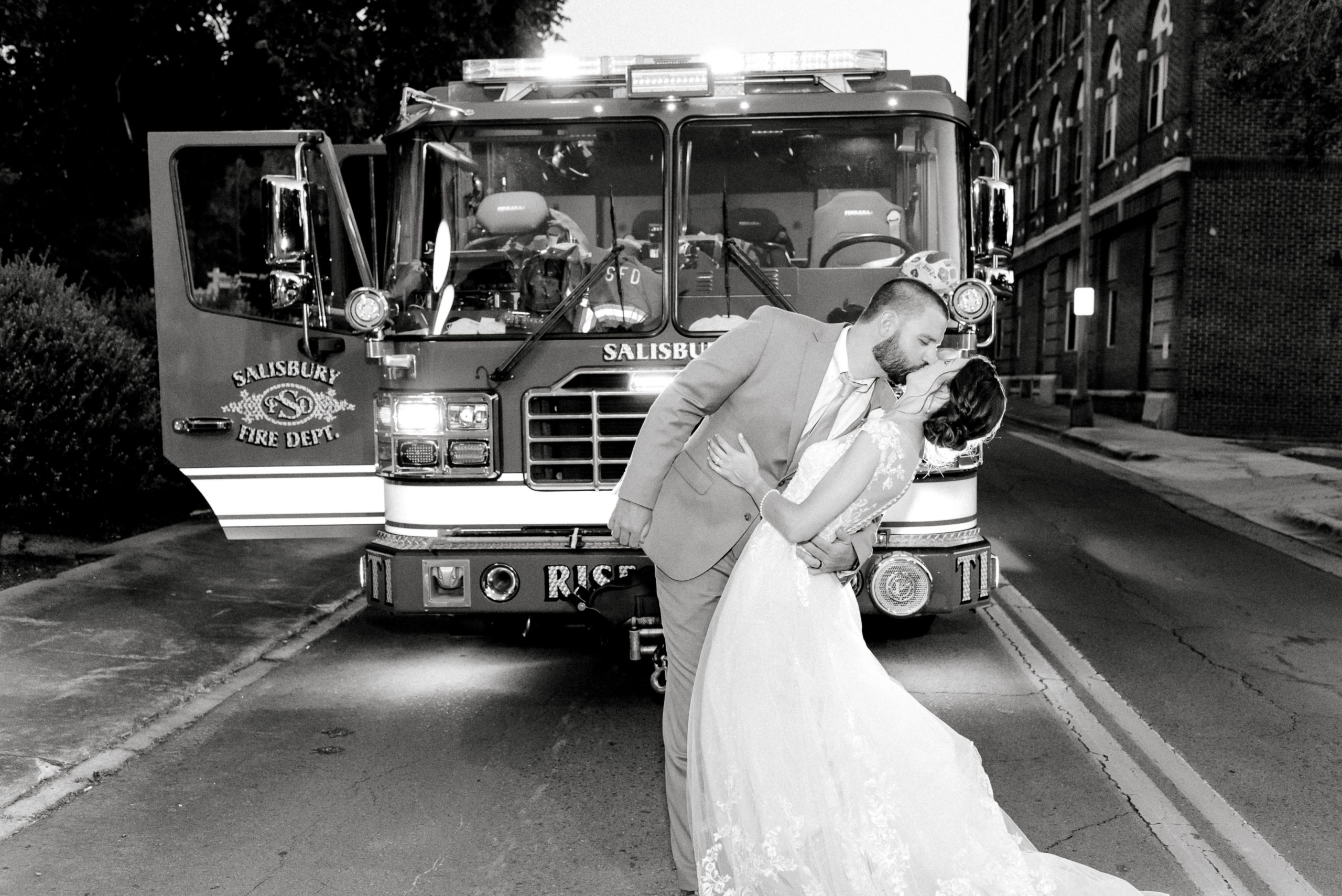 bride and groom in front of fire truck