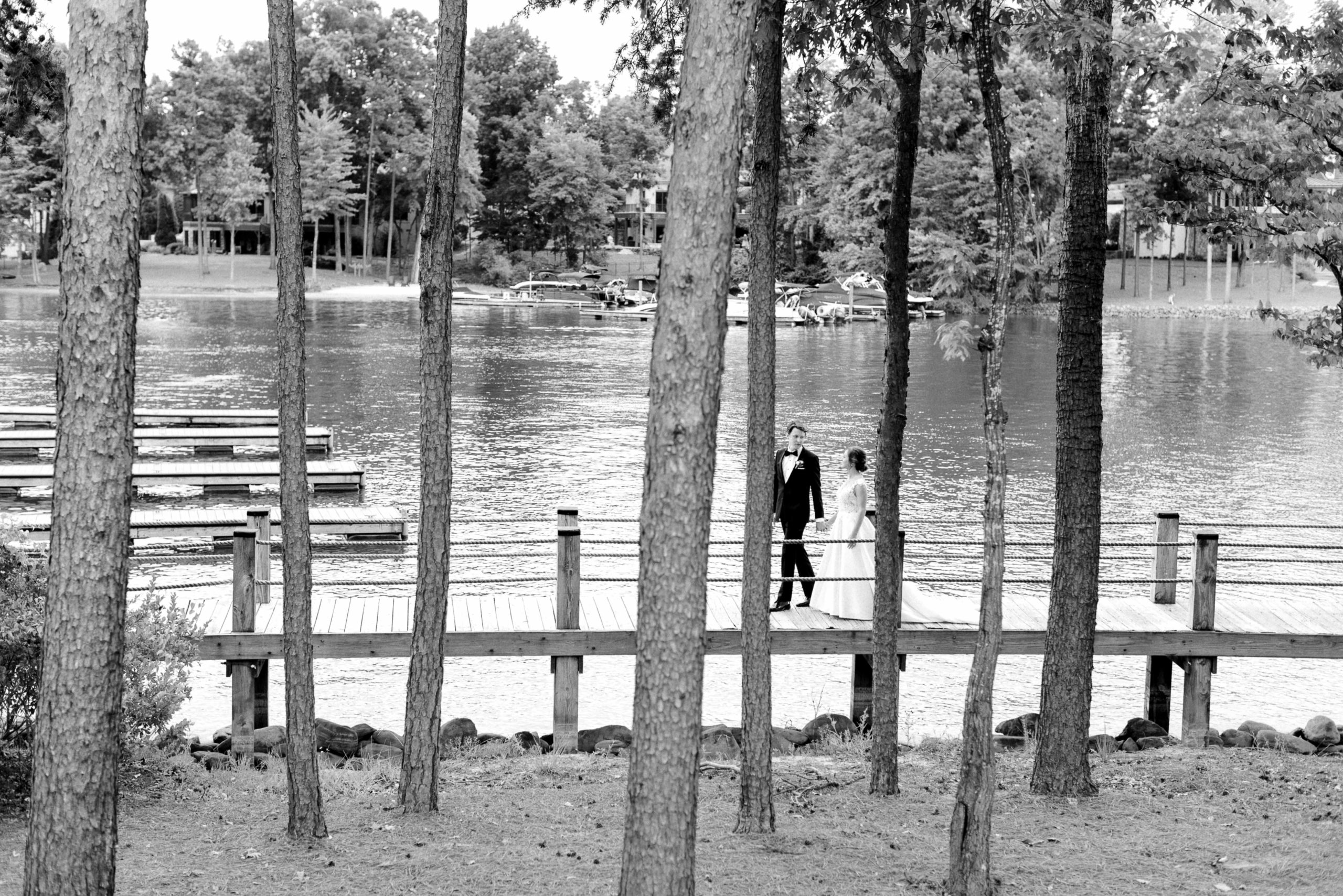 bride and groom walking along the lake